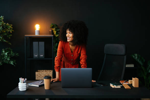 istock Young manager smiling and working on a laptop in her office 2190232100