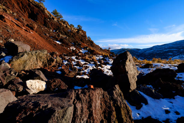 Lava Rocks at Sunset Scenic Landscape - Golden hour light on sidelit rocks, snow patches and mountain views.