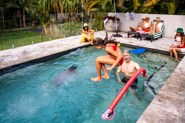 istock Young girl jumping over noodle float and into swimming pool 2190233747
