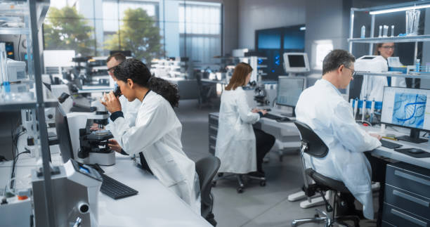 istock Medical Research and Development Laboratory: Beautiful Hispanic Female Scientist Looking at a Sample in a Petri Dish Under a Microscope. Advanced Biotechnology Lab 2190233913