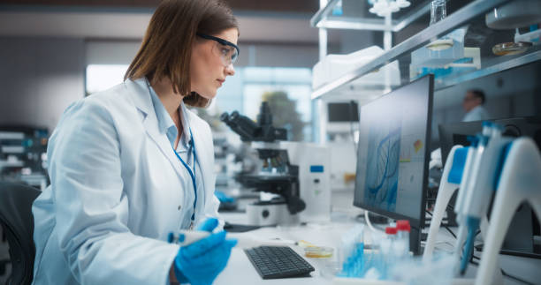 istock Caucasian Female Research Scientist Using Computer in a Modern Laboratory. Scientists are Conducting Research with the Help of Microscopes and Desktop Computers 2190233977