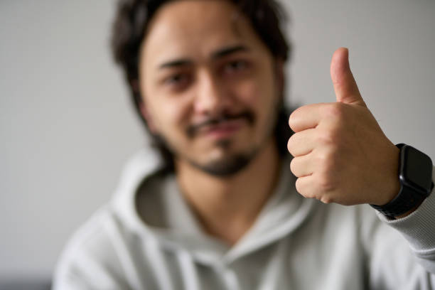 istock Young man showing thumbs up sign, approving and agreeing 2190235725