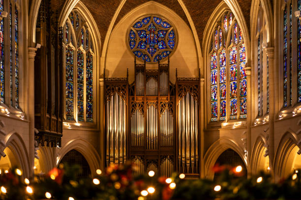 A beautifully decorated church interior with Christmas garlands, red ribbons, and warm lighting.