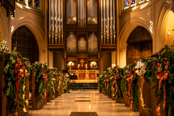 A beautifully decorated church interior with Christmas garlands, red ribbons, and warm lighting.