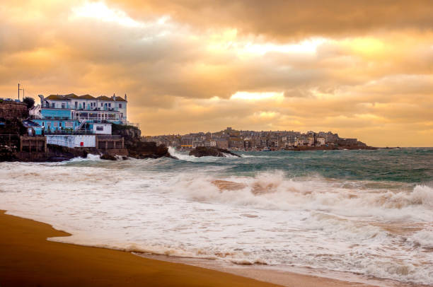 sunlit clouds giving a beautiful orange and golden glow over the town and beach.