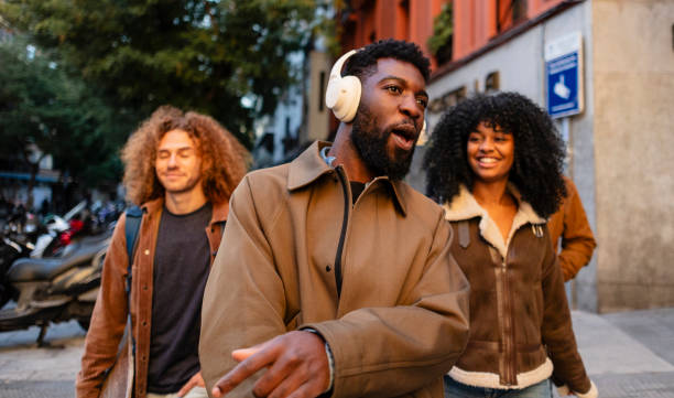 istock Young tourists exploring city with headphones and making gestures 2190244536