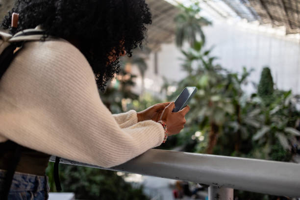 istock Young woman using smartphone in indoor garden 2190245063