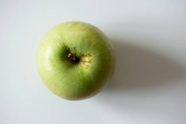 Top view of a green apple against a white background