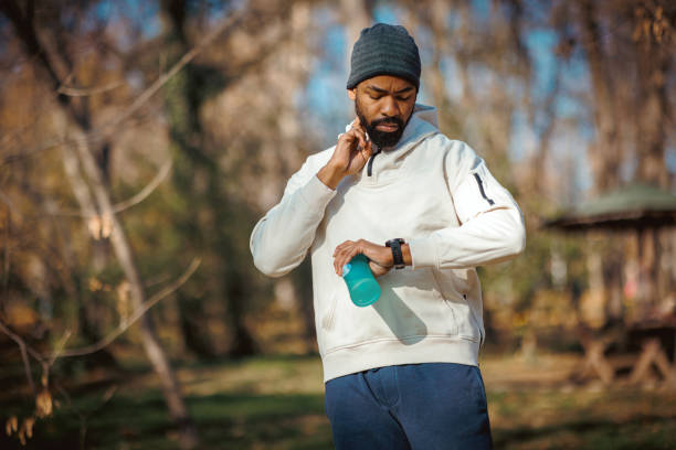 istock Young sportsman checking time on smartwatch during exercising in nature 2190251606