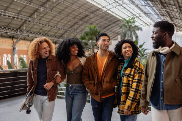 istock Group of diverse young people walking and talking together in station 2190251752