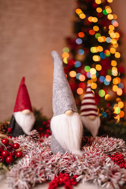 istock Festive Christmas Gnome Decorations with Ornaments and Bokeh Christmas Tree in Background 2190252055