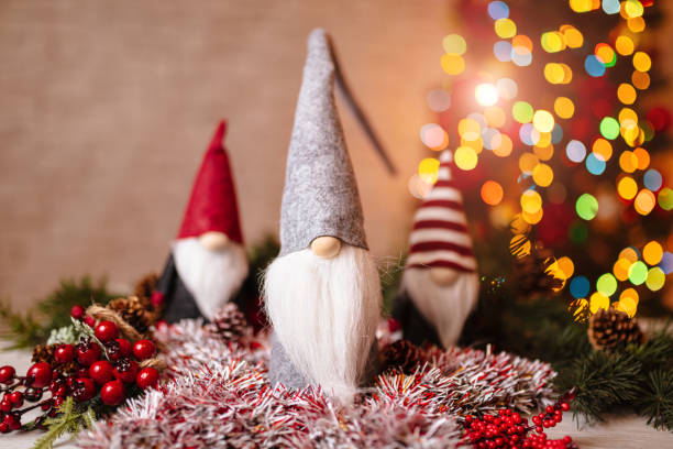 istock Festive Christmas Gnome Decorations with Ornaments and Bokeh Christmas Tree in Background 2190252101