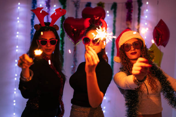 Group of friends enjoying a glamorous party with festive decorations, red balloons, and sparklers, creating an atmosphere of celebration and joy in a modern indoor environment