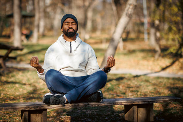 istock Young man meditating in lotus position on park bench 2190252924