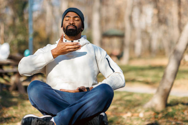 istock Young man practicing breathing exercises in a park during a sunny day 2190253178