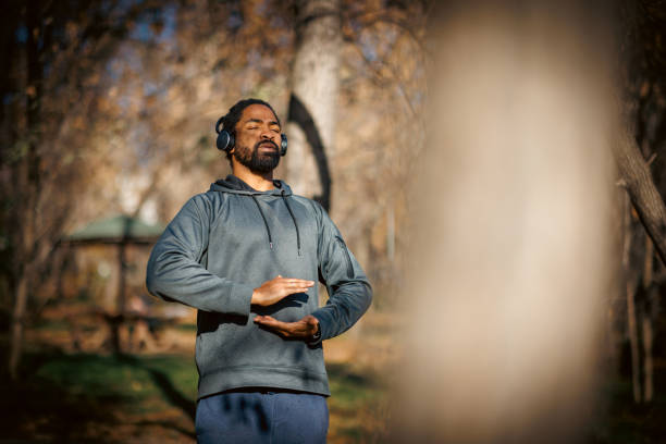 Man meditating outdoors with headphones in autumn