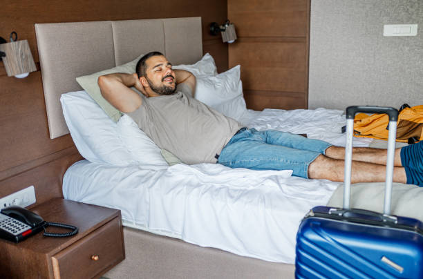 istock Man relaxing on bed in a hotel room 2190254730