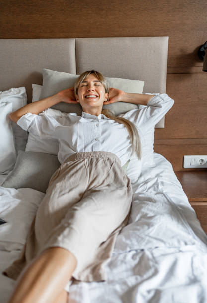istock Woman relaxing on bed in a hotel room 2190254972