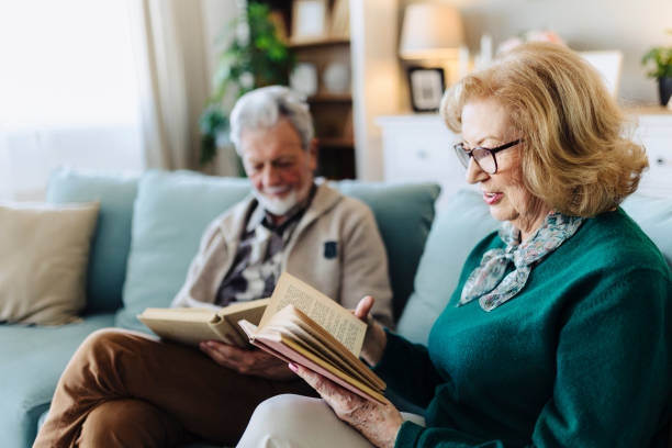 istock Senior couple reading book at home 2190258672