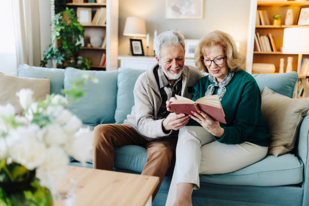 istock Senior couple reading book at home 2190258729
