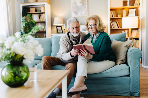 istock Senior couple reading book at home 2190259339