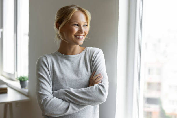 istock Pretty woman looking through window 2190260243