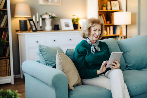 istock Shot of an elderly female sitting and using her tablet at home 2190260575