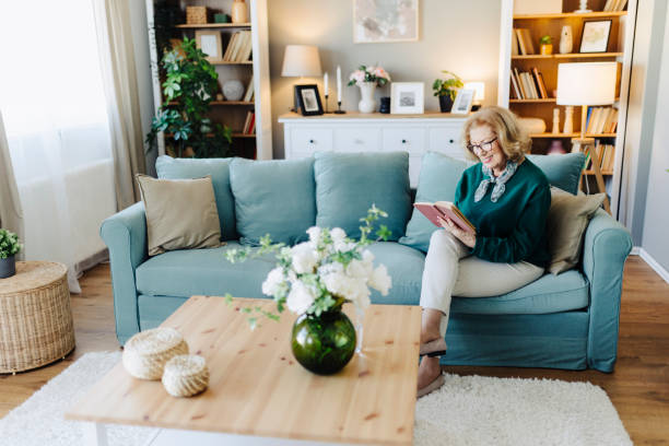 istock Senior woman reading book, sitting on sofa and resting at home 2190260687