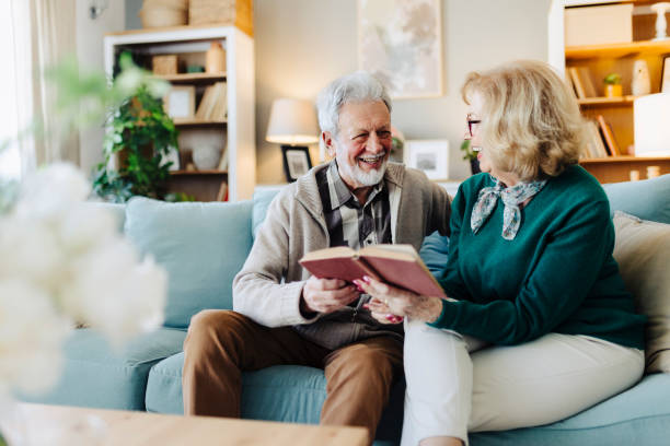 istock Senior couple reading book at home 2190261118