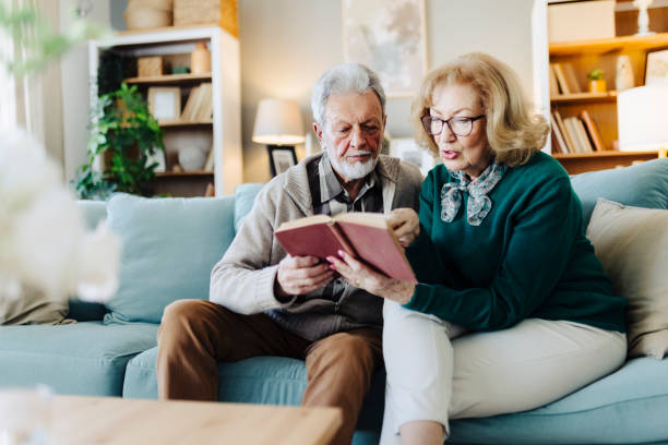 istock Senior couple reading book at home 2190261594