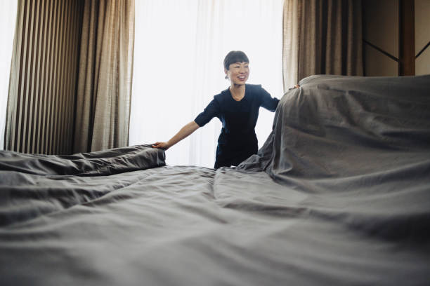 istock Chambermaid changing bed linen on the bed in a hotel room 2190263408