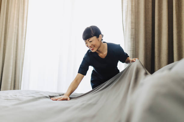 istock Chambermaid changing bed linen on the bed in a hotel room 2190263471