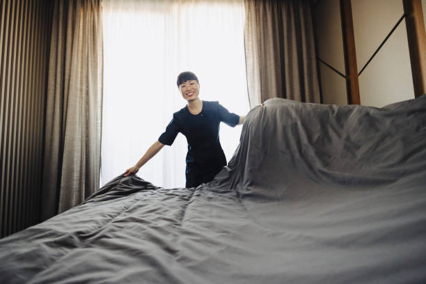 istock Chambermaid changing bed linen on the bed in a hotel room 2190263493
