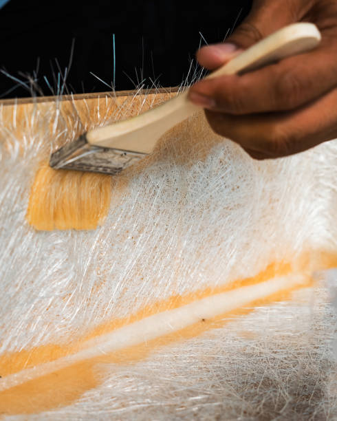 istock sweeping a solution across fibreglass sheets on a box made of wood. A DIY project at home. 2190263529