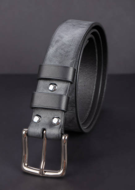 istock Black leather belt with metal buckles on a dark gray background. 2190264522