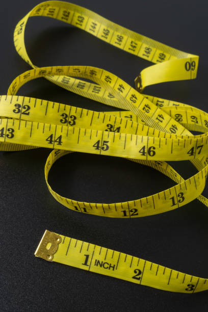 istock Tailor's tape measure on black background 2190264688
