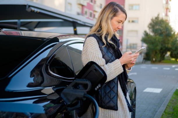 istock 40 year old woman charging electric car 2190264988