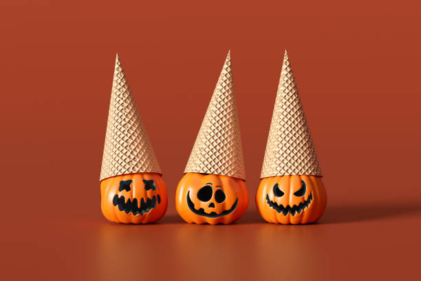 istock Three halloween pumpkins wearing ice cream cones on orange background 2190265728