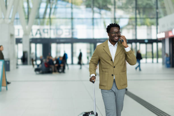 istock Business Professional Traveling While Talking on a Smartphone in Modern Airport 2190267155
