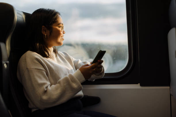 istock Young Woman Using Smartphone While Traveling On Public Transportation During Sunrise 2190270106