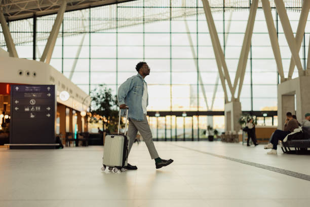 istock Man Walking with Suitcase in Modern Airport Terminal 2190270134