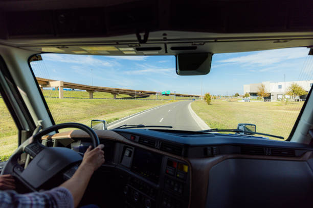 A truck driver's perspective navigating through a highway interchange on a sunny day, showcasing modern highways and transportation infrastructure.
