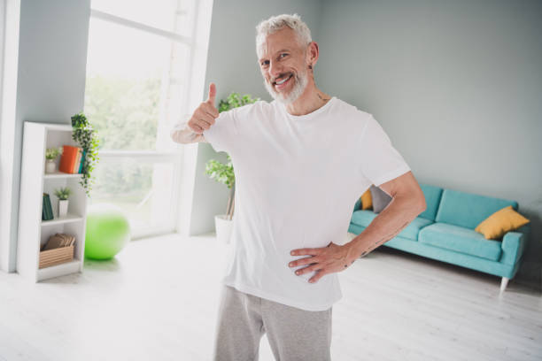 istock Smiling elderly man in casual attire giving thumbs up in a bright modern indoor setting 2190274982