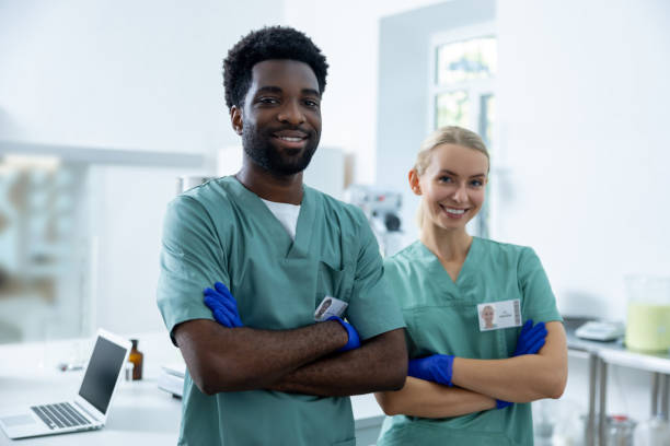 istock Man standing in hospital lab cooperating with diverse woman practitioner at work 2190277132