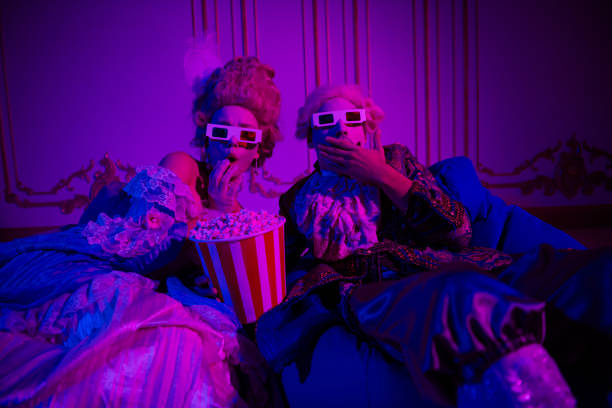 istock Two people dressed in elegant baroque costumes, enjoying a theme party with popcorn under neon lights 2190277344
