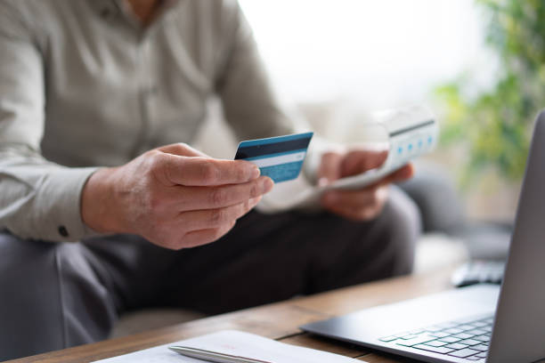 istock Senior man paying bills online using credit card and laptop 2190281064