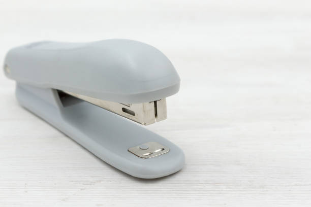 istock Gray stapler on white wooden background. office stationery. 2190282344