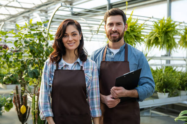 istock Two workers in a greenhouse looking positive and contented 2190284194