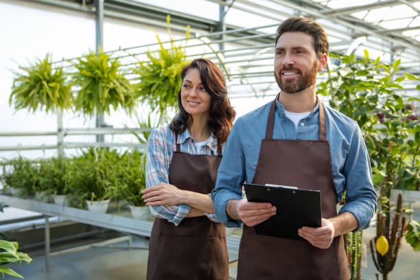 istock Two workers in a greenhouse looking positive and contented 2190284214