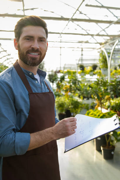 istock Male supervisor working in a greenhouse and looking positive 2190284240